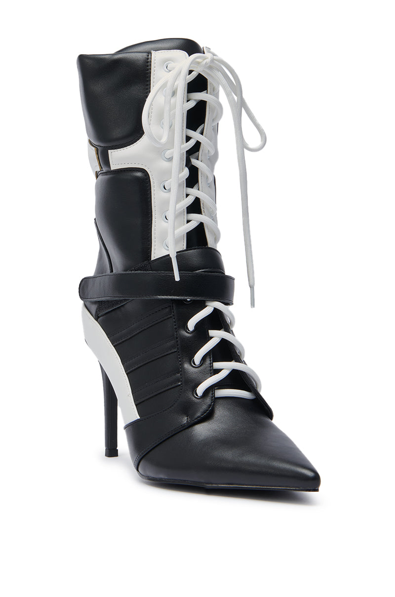 The AZALEA WANG CHAUSIKU BLACK SPORTY BOOTIE is a black and white ankle boot featuring a stiletto heel, pointed toe, lace-up front, and a strap detail across the midfoot for added style.