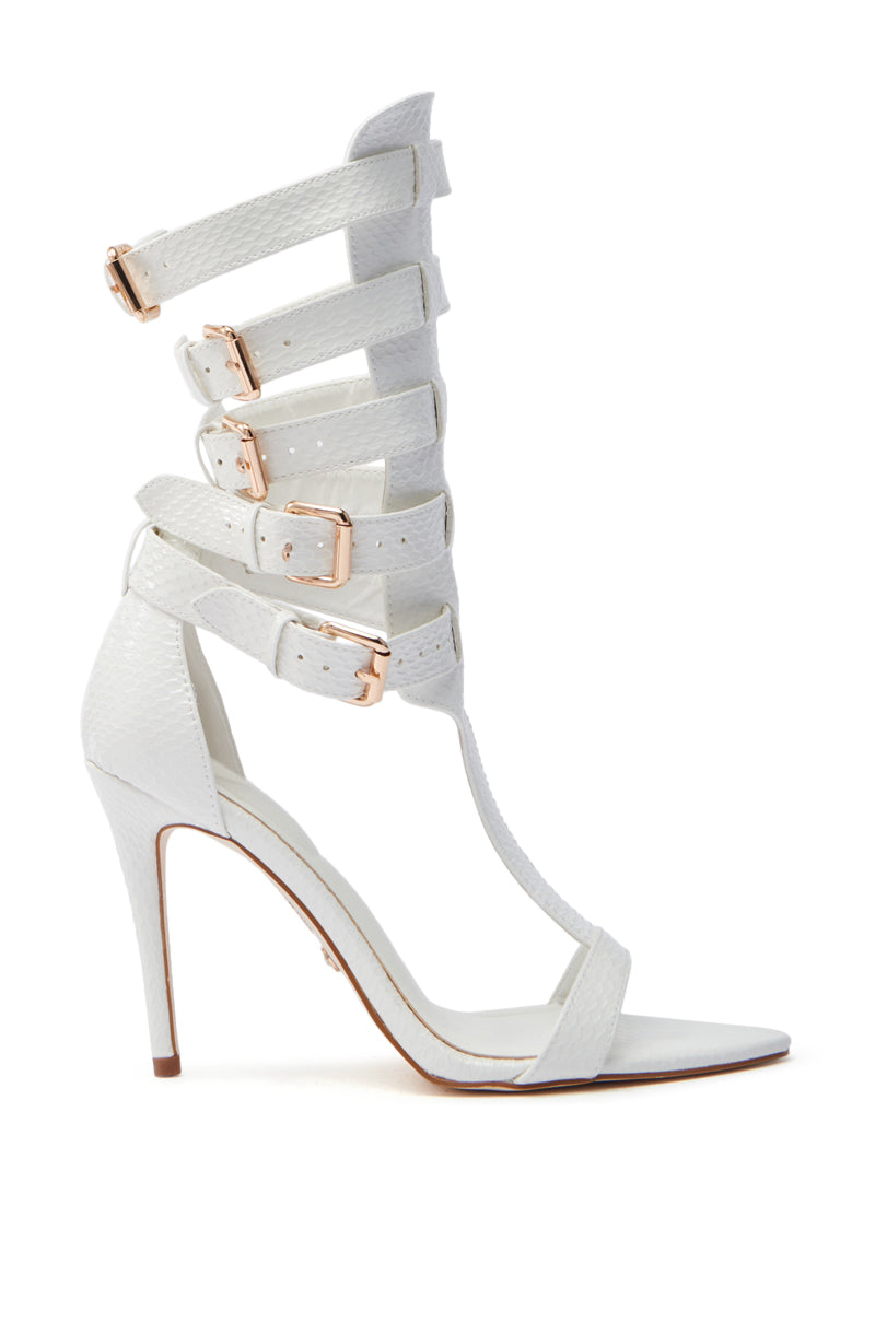 The AZALEA WANG CHERELL White Gladiator Sandal Stiletto is a stunning vegan patent leather sandal featuring an open toe, stiletto heel, and multiple ankle-climbing strappy buckles with metallic clasps.