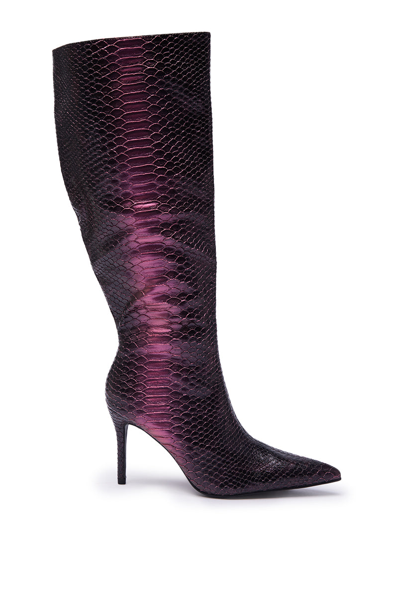 The AZALEA WANG CHERICE PURPLE SNAKESKIN STILETTO BOOT is a knee-high, pointed-toe, faux leather boot with a sleek stiletto heel and bold faux snakeskin texture in a shiny purple finish for a standout look.