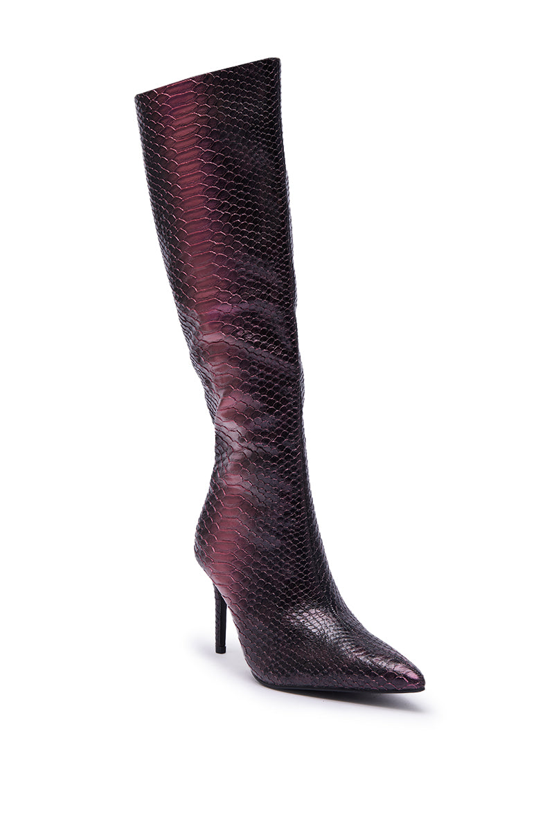 The AZALEA WANG CHERICE PURPLE SNAKESKIN STILETTO BOOT is a tall, faux leather knee-high boot with a pointed toe and stiletto heel, showcasing a shiny purple snakeskin texture, displayed upright on a white background.