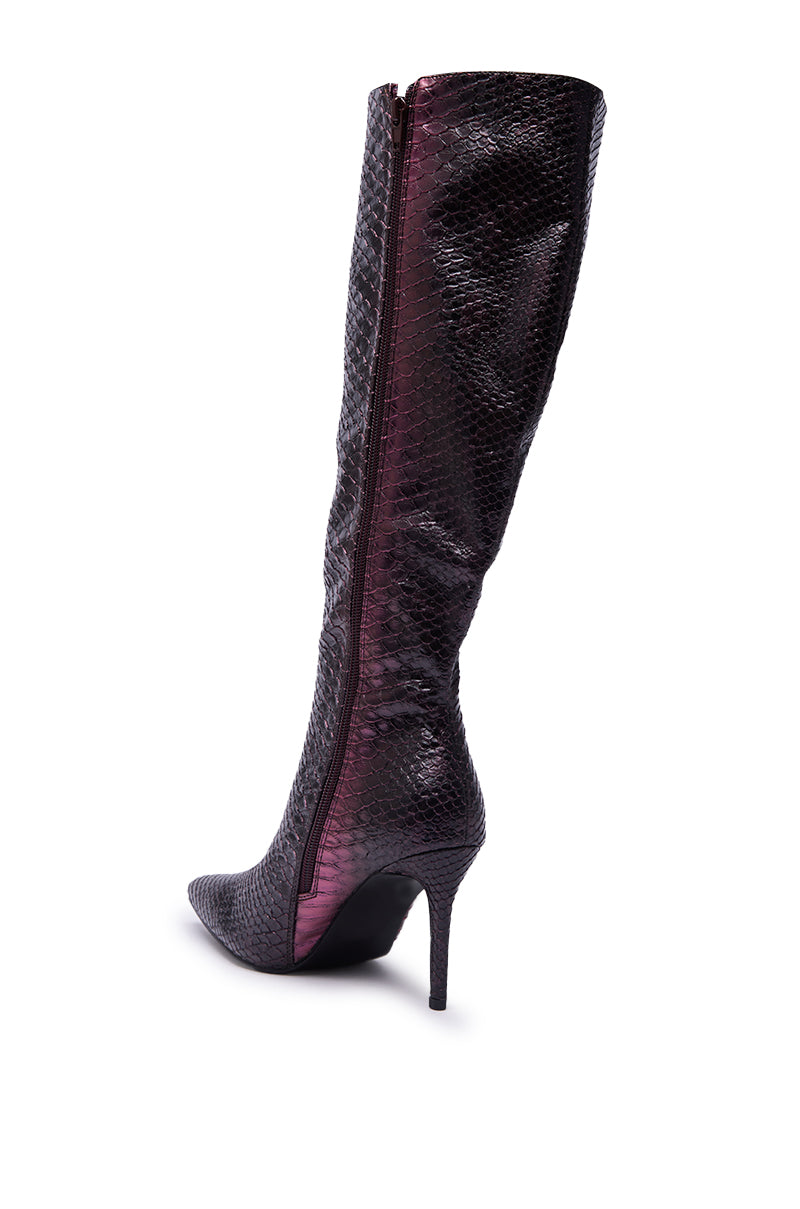 The AZALEA WANG CHERICE PURPLE SNAKESKIN STILETTO BOOT is a bold, knee-high boot in dark faux leather with a pointed toe, side zipper, and striking purple snakeskin finish for standout style.
