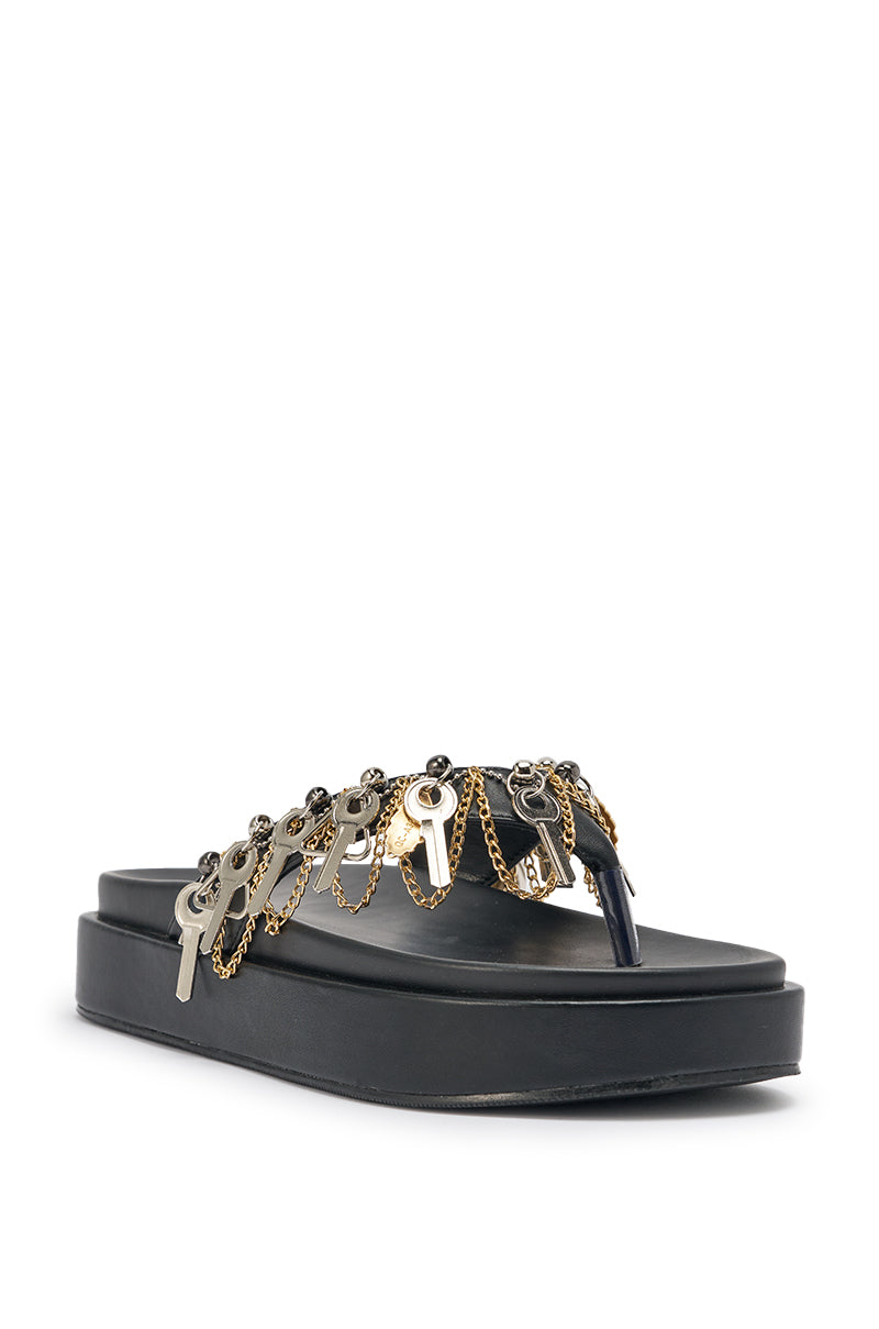 The AKIRA GOLD CHRISTEN BLACK KEY EMBELLISHED NOVELTY PLATFORM SANDAL showcases black faux leather, chunky platforms, and bold metallic key and chain accents across the upper strap, set against a white background. 6