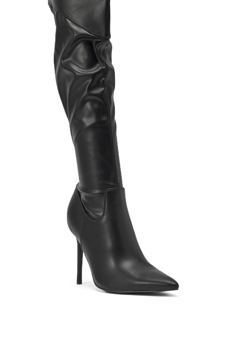 A close-up of the AKIRA GOLD CHROMEA BLACK THIGH HIGH STILETTO BOOT, featuring black faux leather, a sleek fitted design, pointed toe, stiletto heel, and bold thigh-high silhouette. 5
