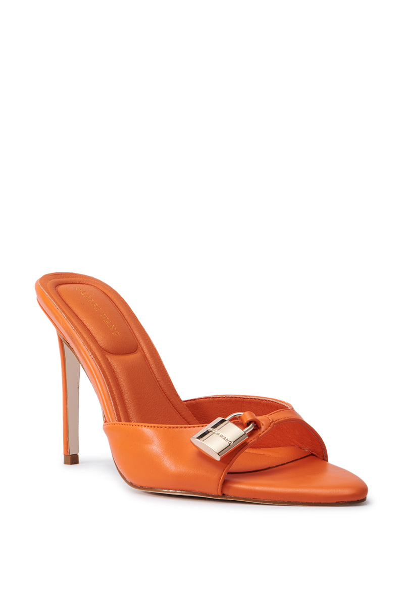 The AZALEA WANG CHUG ORANGE SANDAL is a striking orange high-heeled mule with a pointed toe and faux leather design, featuring a decorative silver buckle on the front strap and a slim stiletto heel, ideal for making a bold statement.