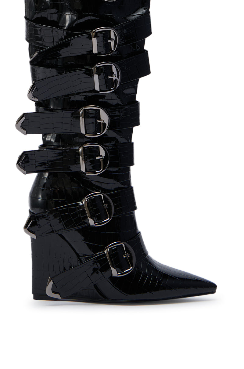 The AZALEA WANG CINZIA BLACK CROC BUCKLE WEDGE BOOT is a knee-high wedge with a pointed toe, crocodile-texture finish, and seven large silver buckle straps up the front.