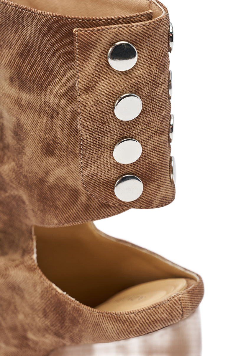 Close-up of the AZALEA WANG CIRCOS BROWN WEDGE BOOTIE, featuring textured brown faux leather, six silver studs on the side, a cutout detail, visible stitching, an ankle-high shaft, and an open back above the heel.