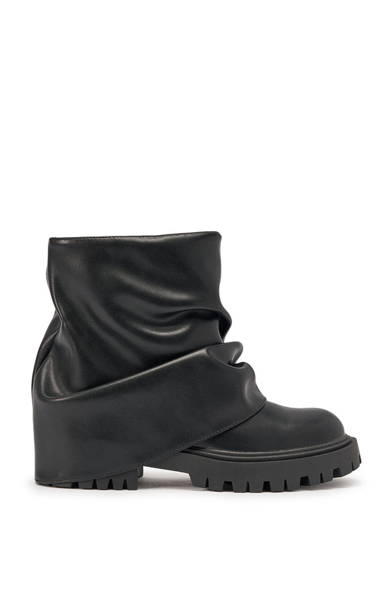 The AZALEA WANG CLARKE BLACK PU SLOUCHY SHORT SHAFT COMBAT BOOTIE features a black, fold-over slouchy design with chunky lug soles, displayed against a plain white background. 4