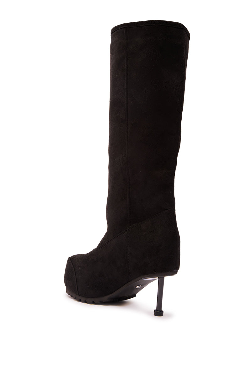 The AZALEA WANG CLEDQYN BLACK FAUX SUEDE BOOT is a knee-high style with a high stiletto heel, platform sole, and slightly pointed toe, shown from a rear side angle on a white background.