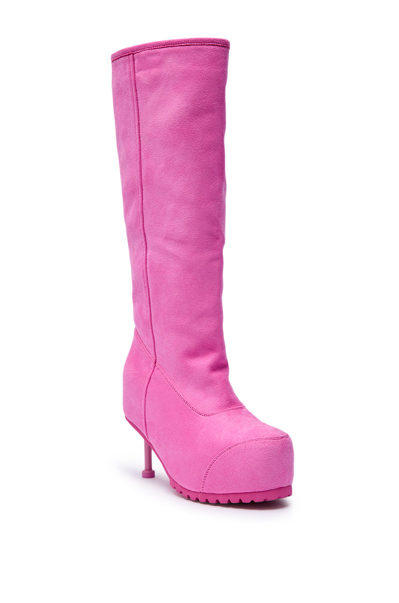 The AZALEA WANG CLEDQYN Pink Suede Stiletto Boot, a knee-high, bright pink suede boot with a chunky sole and high heel, is showcased against a white background. 4