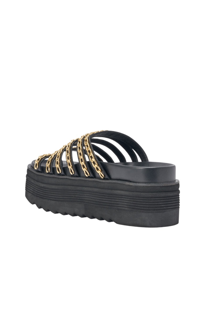 The AKIRA CLEMENTE GOLD CHAIN DETAIL FLATFORM SANDAL, a black faux leather sandal with multiple horizontal straps and gold chain accents, is shown from the back and side against a white background. 5