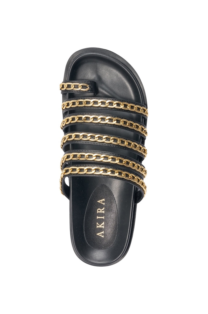 The AKIRA CLEMENTE GOLD CHAIN DETAIL FLATFORM SANDAL is a chic black faux leather sandal with five gold chain straps and "AKIRA" printed in gold on the insole. 6