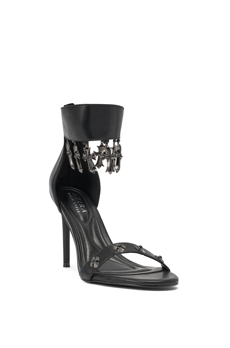 The AKIRA Gold Clergy Black Embellished Sexy Strap Stiletto Heel features thin straps, an ankle cuff, and rhinestone cross accents above the ankle for a chic, gothic-inspired look. 3