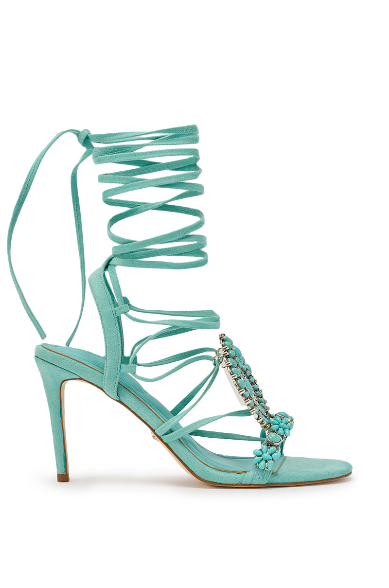 The AKIRA GOLD CLIPSE AQUA HARDWARE EMBELLISHED STILETTO SANDAL features turquoise faux suede, wraparound ankle straps, an open toe, and silver chain with blue flower embellishments—a chic addition to your strappy stiletto collection. 4