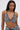 A woman with straight, long hair wears the SHAGGY BRALETTE, a black and white textured halter neck bikini top. She stands against a plain light background, looking directly at the camera with a neutral expression.