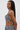 A woman with long, straight hair stands in profile wearing the SHAGGY BRALETTE and matching bottoms in black and white textured fabric, highlighting a chic bikini silhouette against a plain light background.
