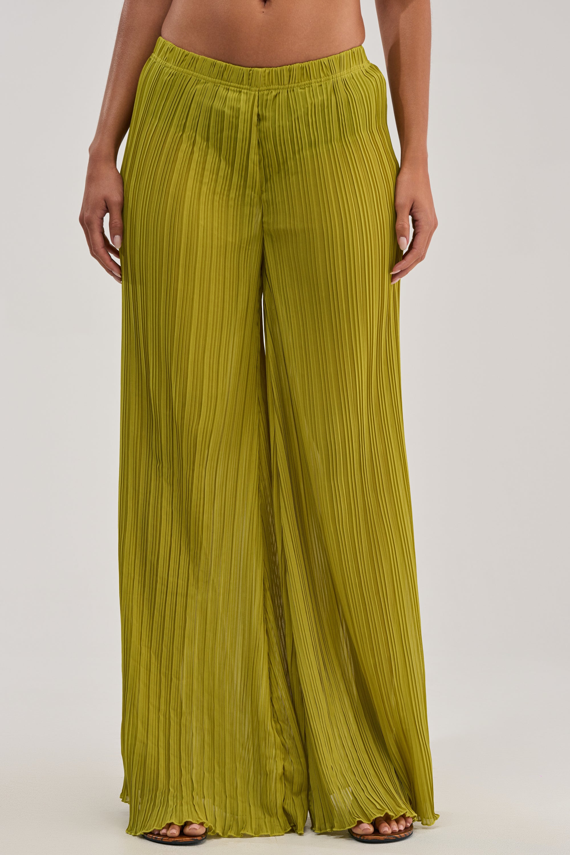 Barefoot against a light background, a person wears the CRUSHIN ON YOU PALAZZO PANT IN CHARTREUSE—lightweight, flowy, and pleated for effortless resort style.