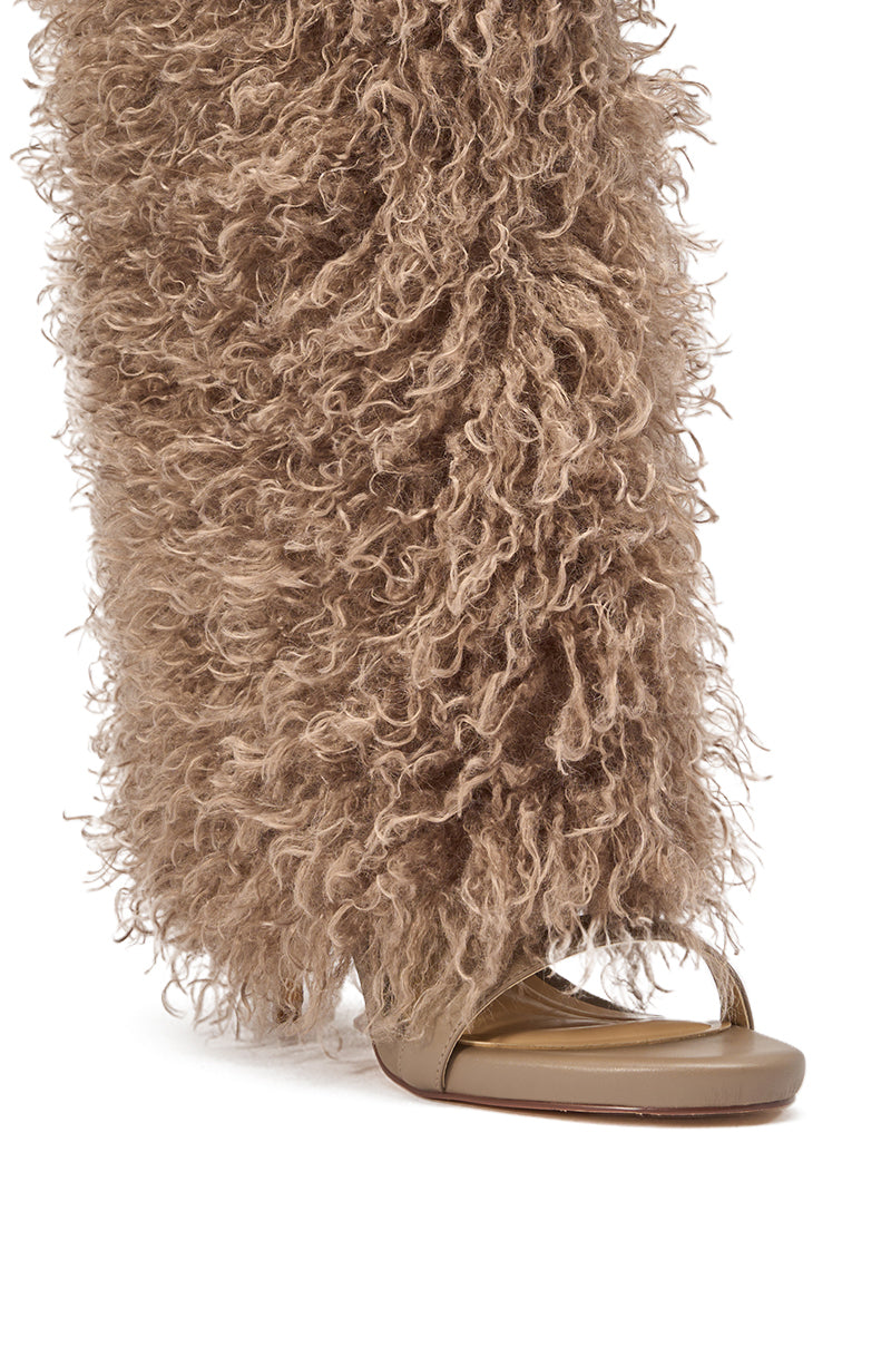 The Azalea Wang CLOUD NINE TAUPE FUR OPEN TOE BOOT features a stiletto sandal design partially covered by long, curly, light brown faux fur pants for a textured, standout fashion statement. 5