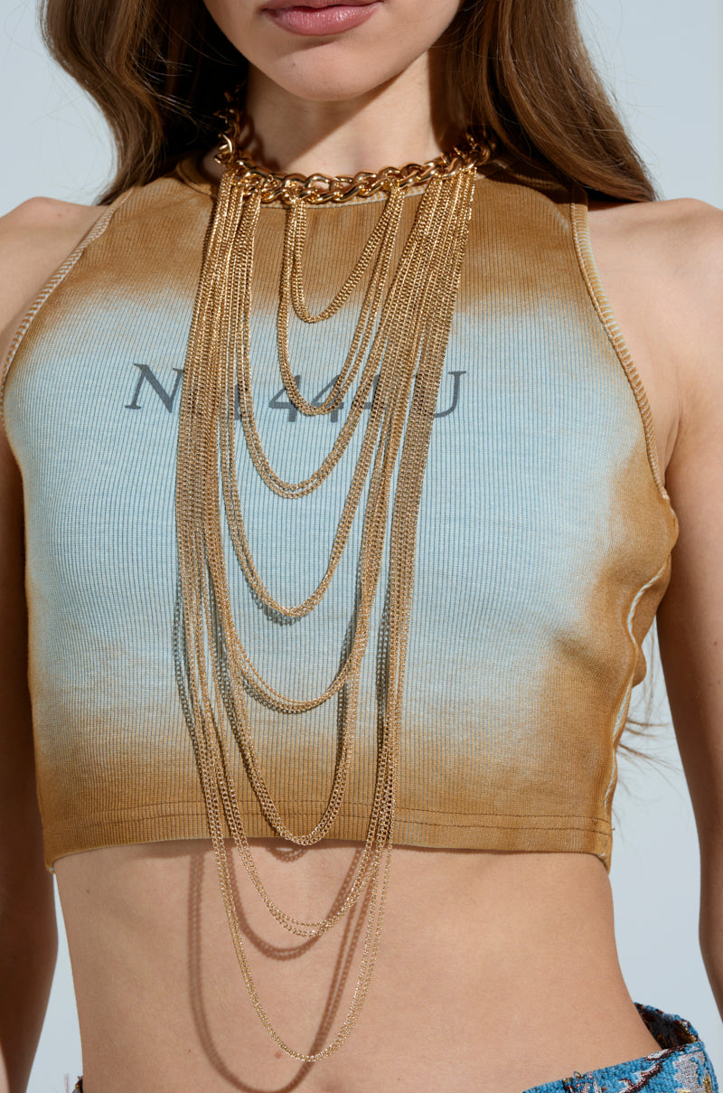 A person wears a sleeveless top with warm gradient hues and "NOWAY" partially visible. They accessorize with a chain link choker and the SO MANY LAYERS NECKLACE, creating an elegant multilayered style against the plain background. 1