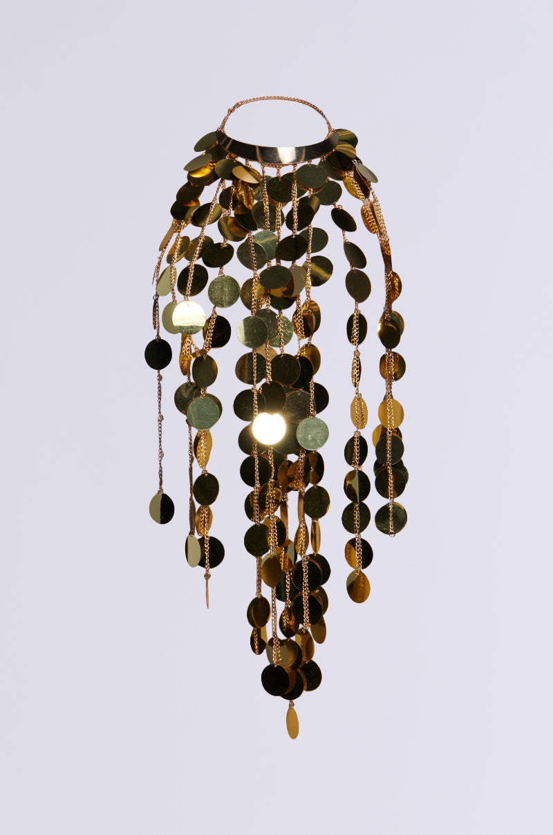 The PARTY STARTER SEQUIN STATEMENT NECKLACE, featuring cascading strands of shiny, oversized sequin embellishments in a gold circular design, creates a luxurious and elegant appearance against a plain background.