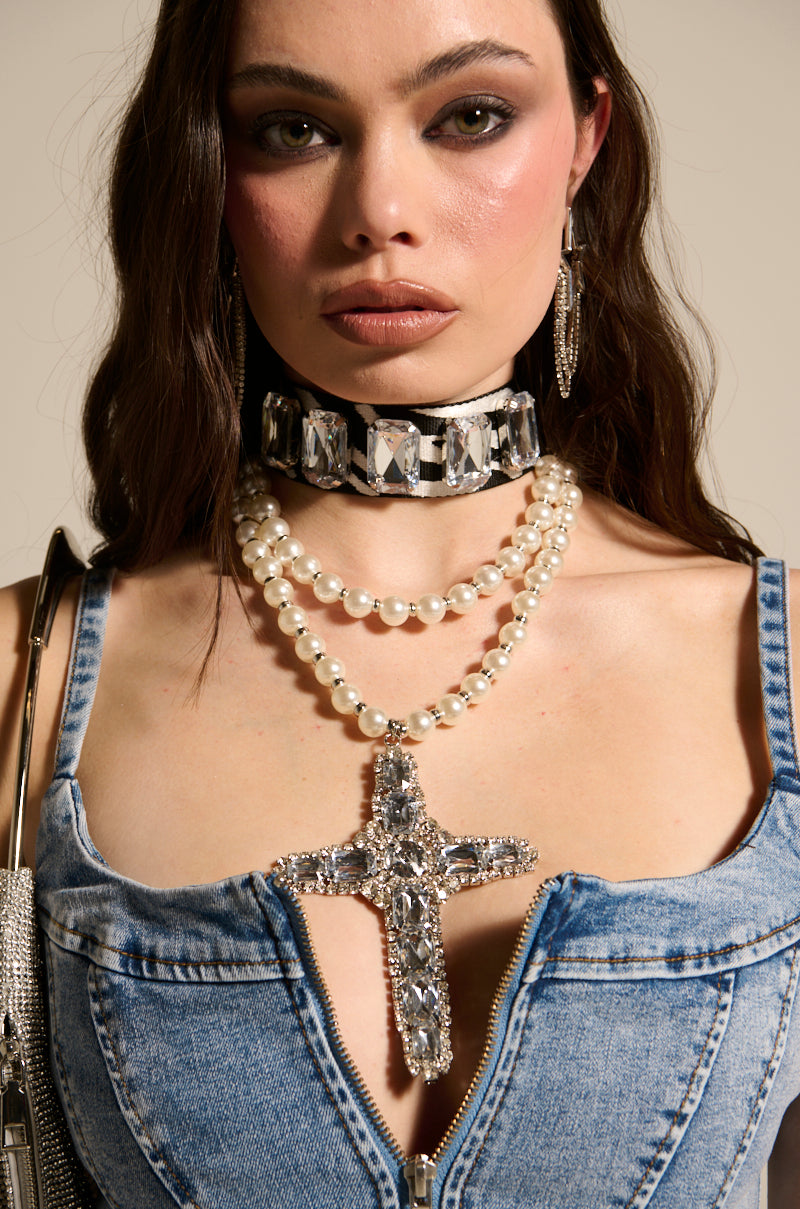 A woman wearing a denim zip-up top, silver earrings, and the WALK ON THE WILD SIDE STATEMENT NECKLACE, looks directly at the camera.