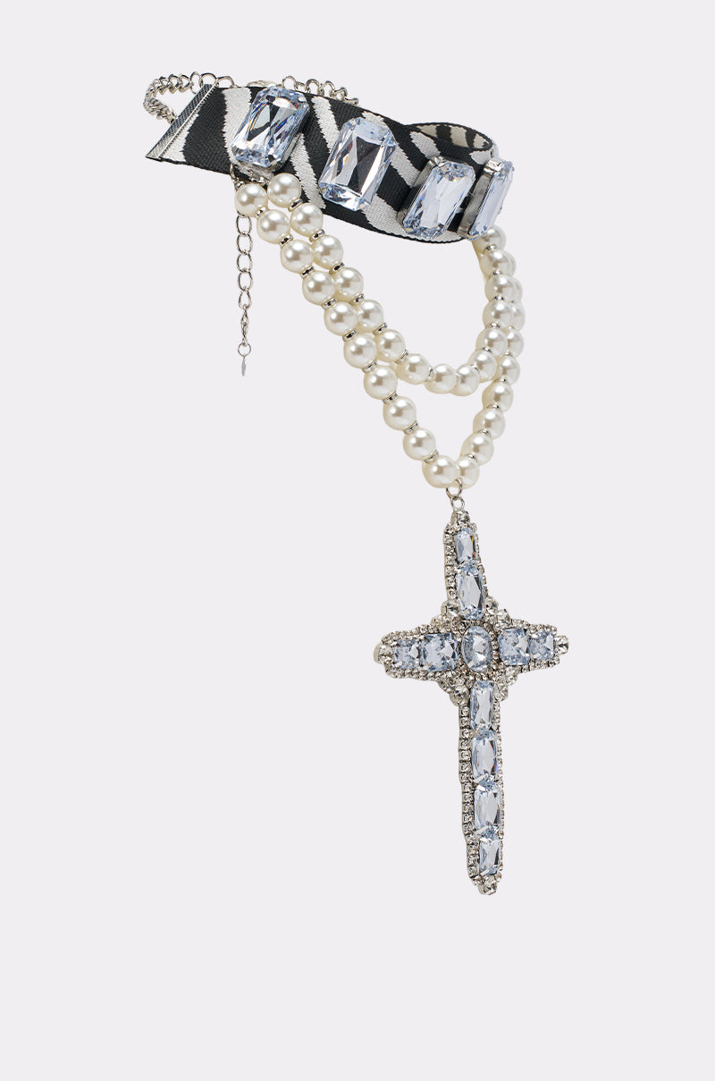 The WALK ON THE WILD SIDE STATEMENT NECKLACE features two pearl strands, a jeweled cross pendant, and a black-and-white striped ribbon accented with silver chain detailing.
