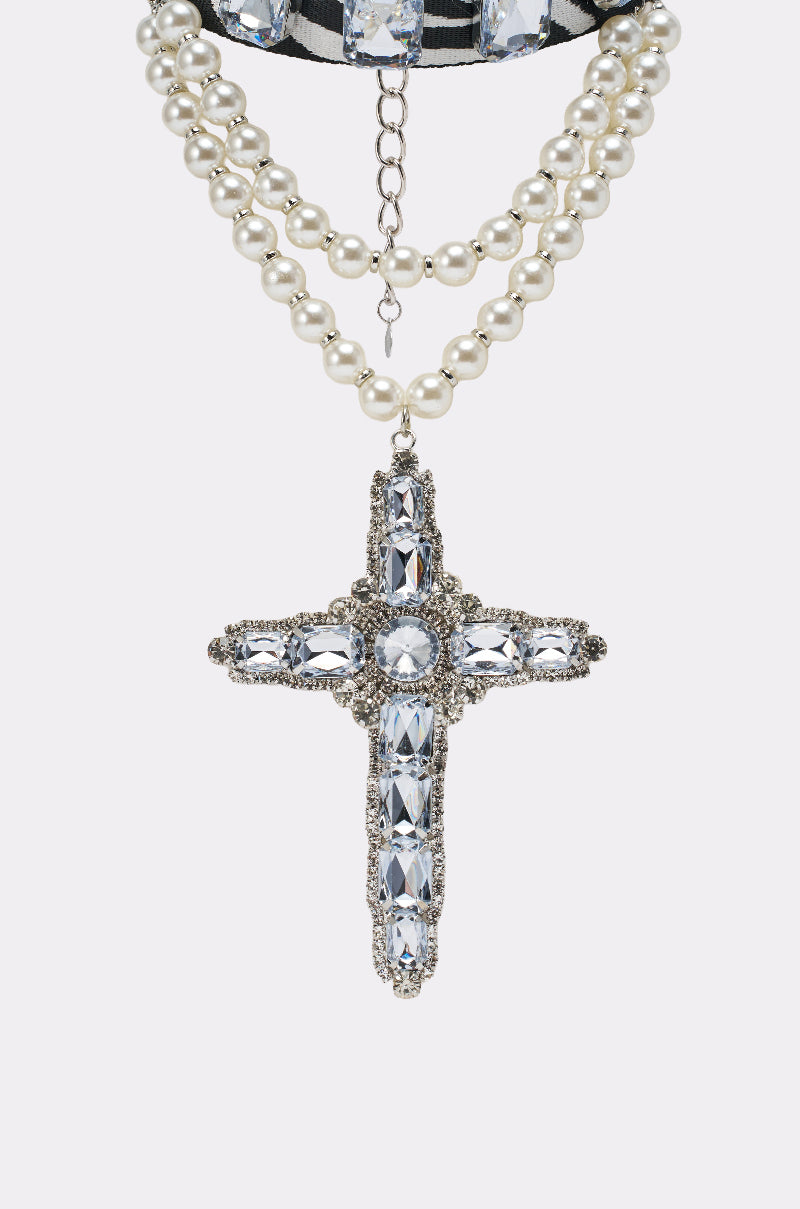The WALK ON THE WILD SIDE STATEMENT NECKLACE features two strands of pearls and a gemstone-studded cross pendant, suspended from a ribbon with an adjustable chain clasp.