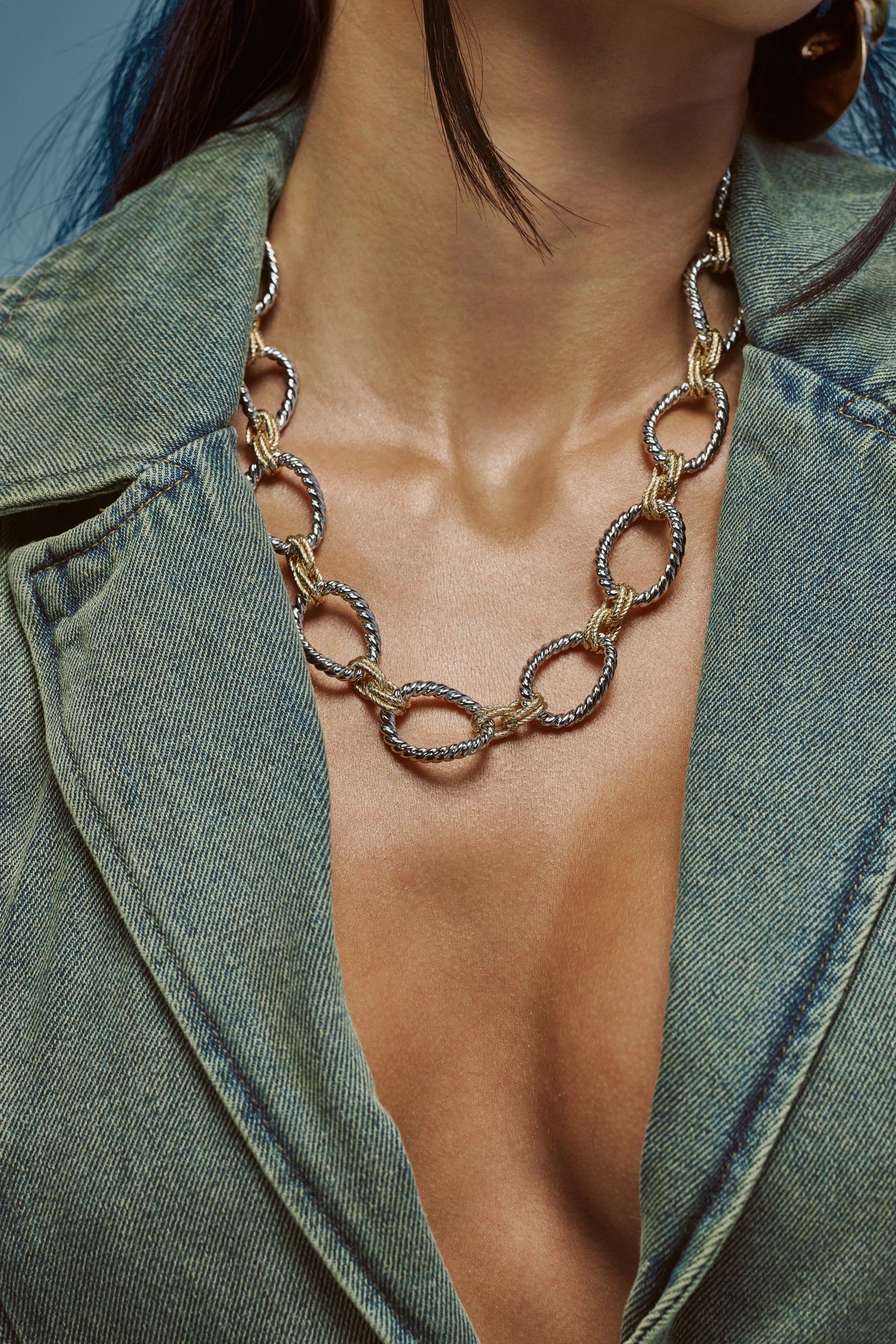 A woman wearing a deep V-neck green denim jacket and the TWO TONE BIG LINK NECKLACE.