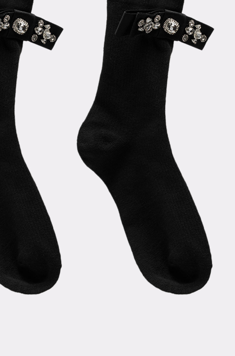 WITH A PUMP EMBELLISHED SOCKS feature black satin bows and sparkling rhinestone accents near the top, showcased on a plain light background. 2
