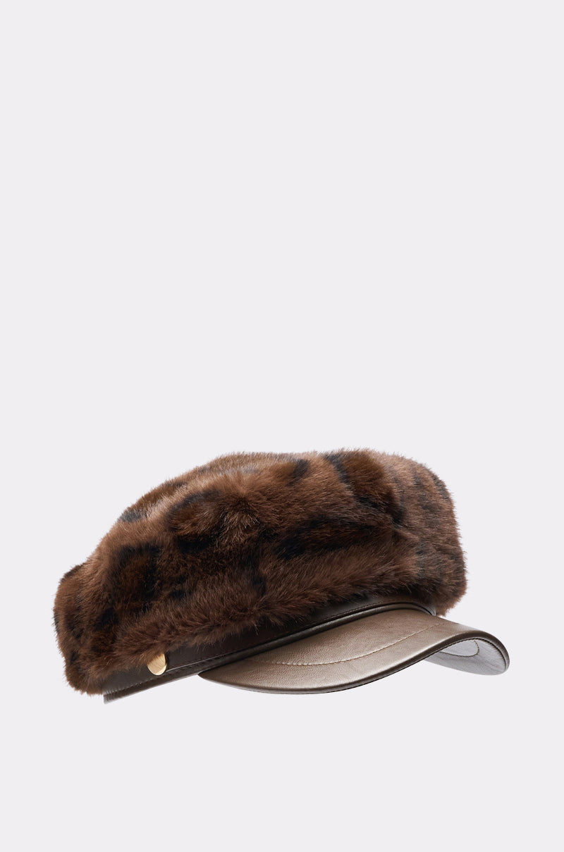 The I AM THE LUXURY FAUX FUR BRIM HAT is a brown leopard print baker boy style with a short, curved leather brim and gold button accents on the side, displayed against a plain light background. 2