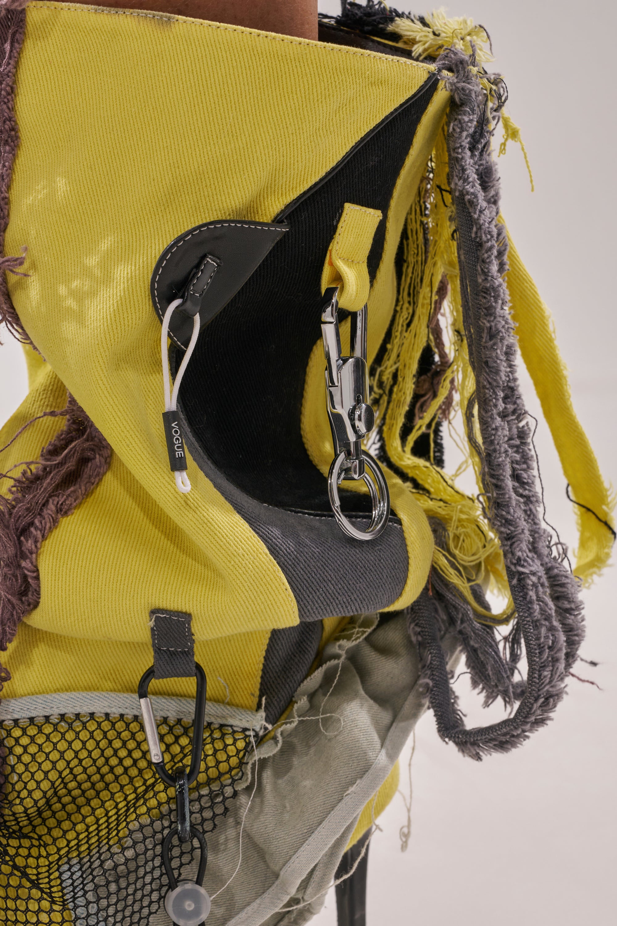 A close-up of the AKIRA GOLD COALESCE SPORTY MIXED MATERIAL STILETTO BOOT shows frayed edges, mesh details, metal hardware, and mixed textures for a rugged, streetwear-inspired look. 6