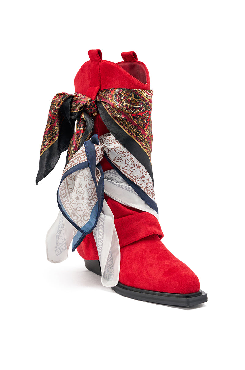 The AZALEA WANG COBALT RED FAUX SUEDE SCARF EMBELLISHED WESTERN BOOTIE features a pointed toe, square heel, and is adorned with colorful patterned silk scarves tied in a bold bow on the side. 5