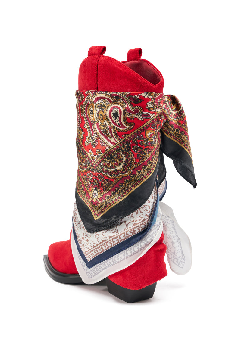 The AZALEA WANG COBALT RED FAUX SUEDE SCARF EMBELLISHED WESTERN BOOTIE features a pointed toe, black sole, and a multicolored paisley-patterned scarf tied around the upper, all crafted in vibrant red faux suede. 6