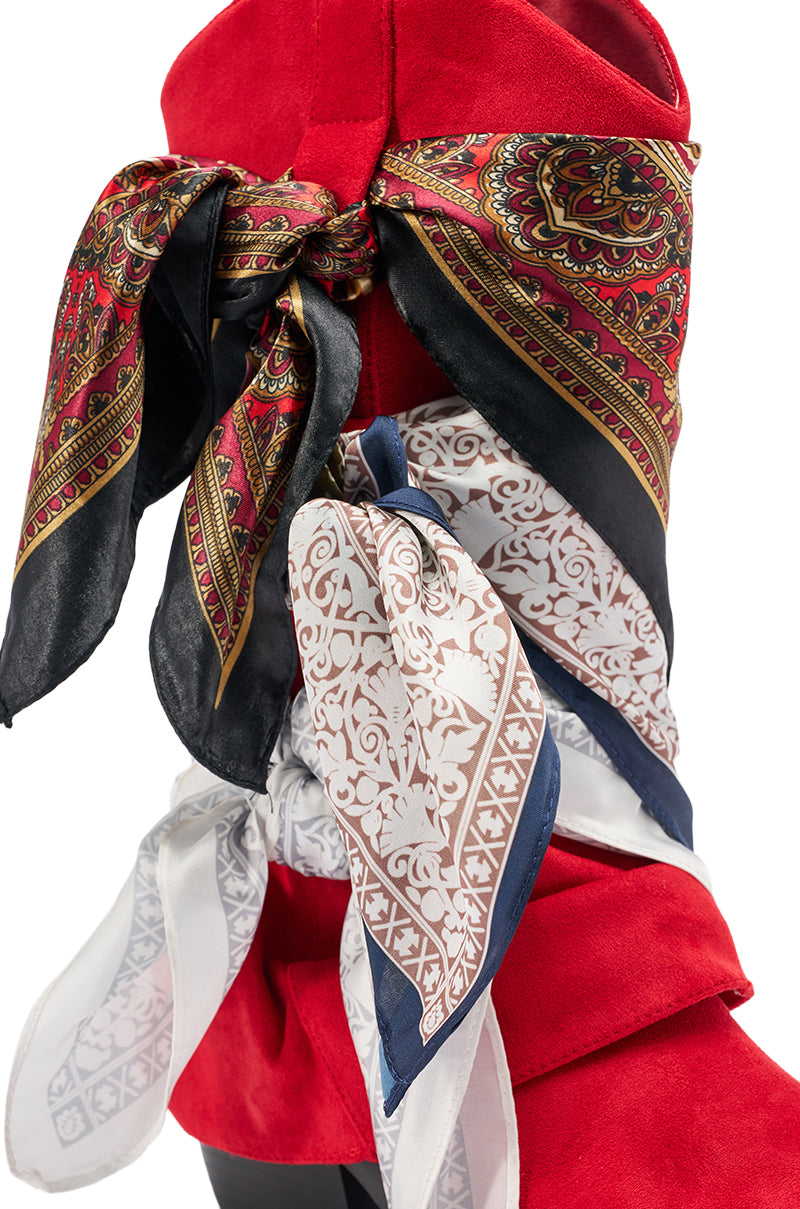 The AZALEA WANG COBALT RED FAUX SUEDE SCARF EMBELLISHED WESTERN BOOTIE is accented with two patterned silk scarves—one red paisley, one white with navy edges—for a bold, eye-catching look. 7