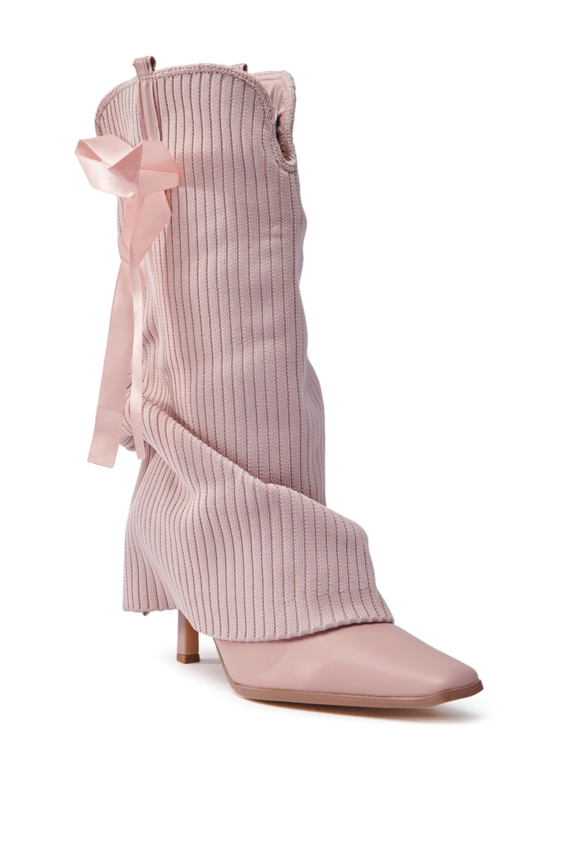The CODEWORDS PINK BOW STILETTO FOLD OVER BOOT is a stylish pink boot with a slouchy, ribbed design, pointed toe, ribbon detail at the back, made from vegan leather, and features a mid-heel.