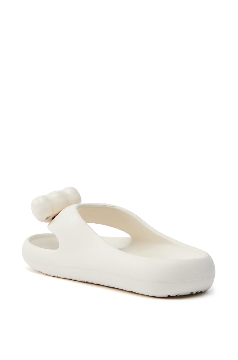 The AKIRA COMPASSION WHITE SANDAL is an almond thong toe sandal in off-white with a thick sole, bulbous details, and a rounded back strap. Crafted from cushy material for comfort, it boasts a modern, sculptural look on a plain white background.