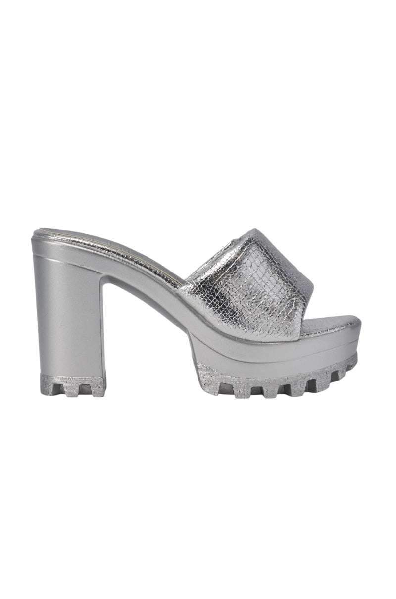 The AKIRA COOLCAT SILVER CROC BLOCK HEEL MULE SANDAL features a metallic silver crocodile-textured faux leather upper, an open toe, chunky block heel, and a stylish lugged sole. 3