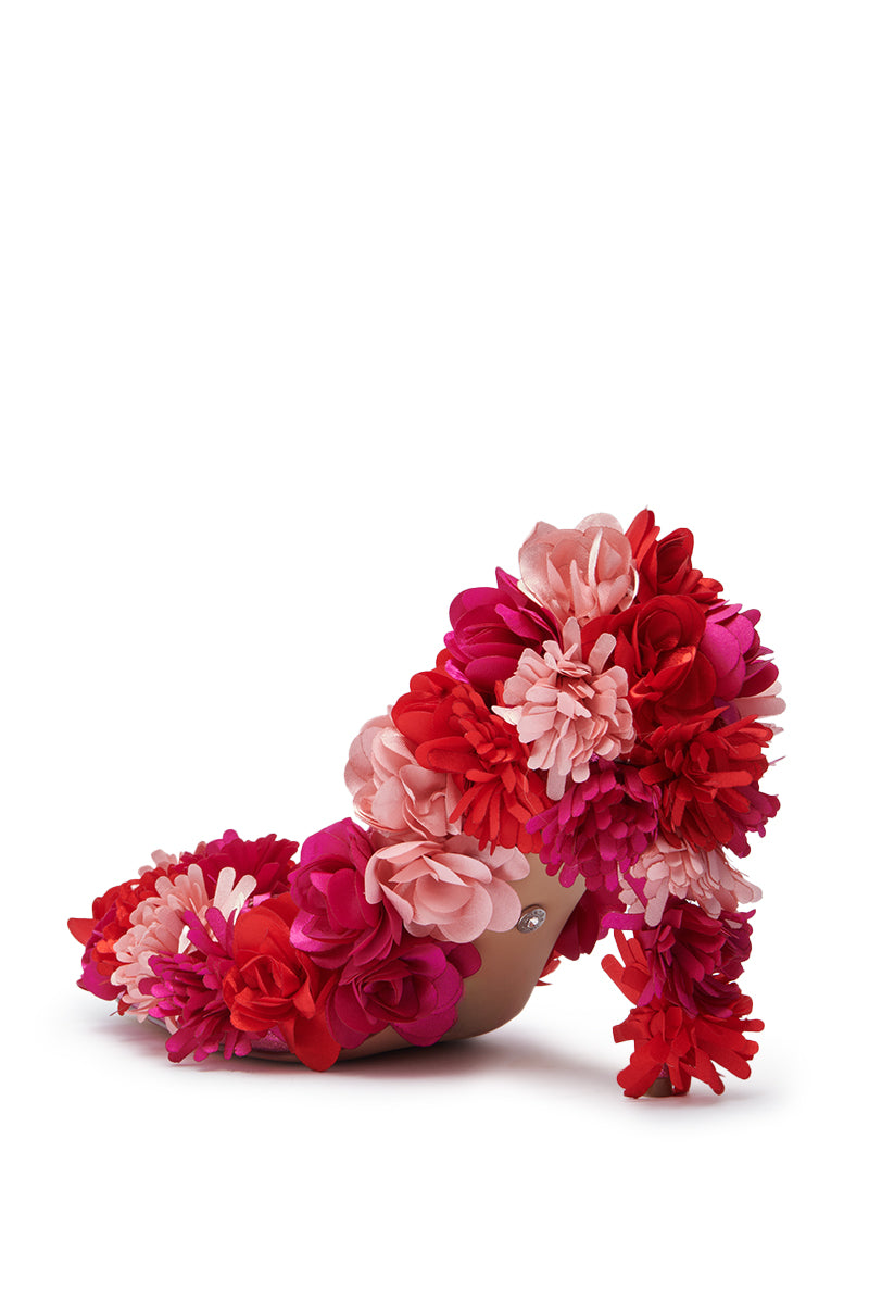 The AZALEA WANG COLLIDGE MULTI FLORAL EMBELLISHED PUMP features a stiletto heel and is adorned with layered artificial flowers in red, pink, and fuchsia, shown against a white background.