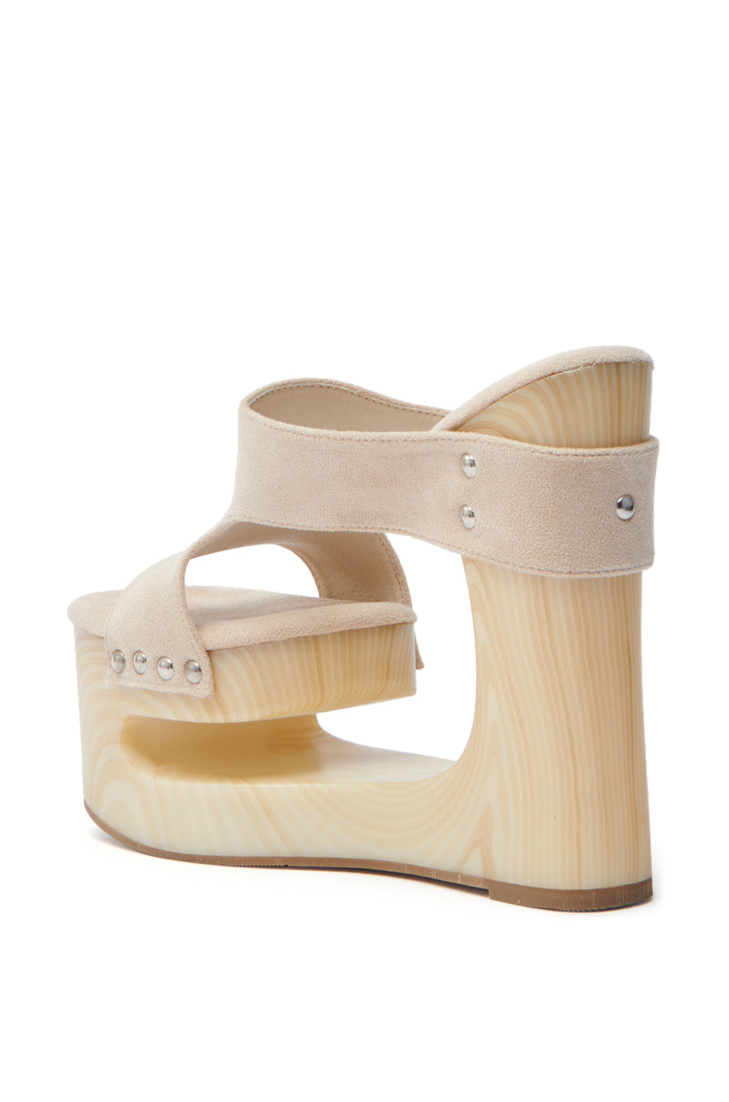 The AZALEA WANG COPSE BEIGE SANDAL features a side view showcasing chic platform sandals with chunky wedge heels, light wood-textured soles, and faux suede beige straps adorned with silver rivet accents for a modern touch.