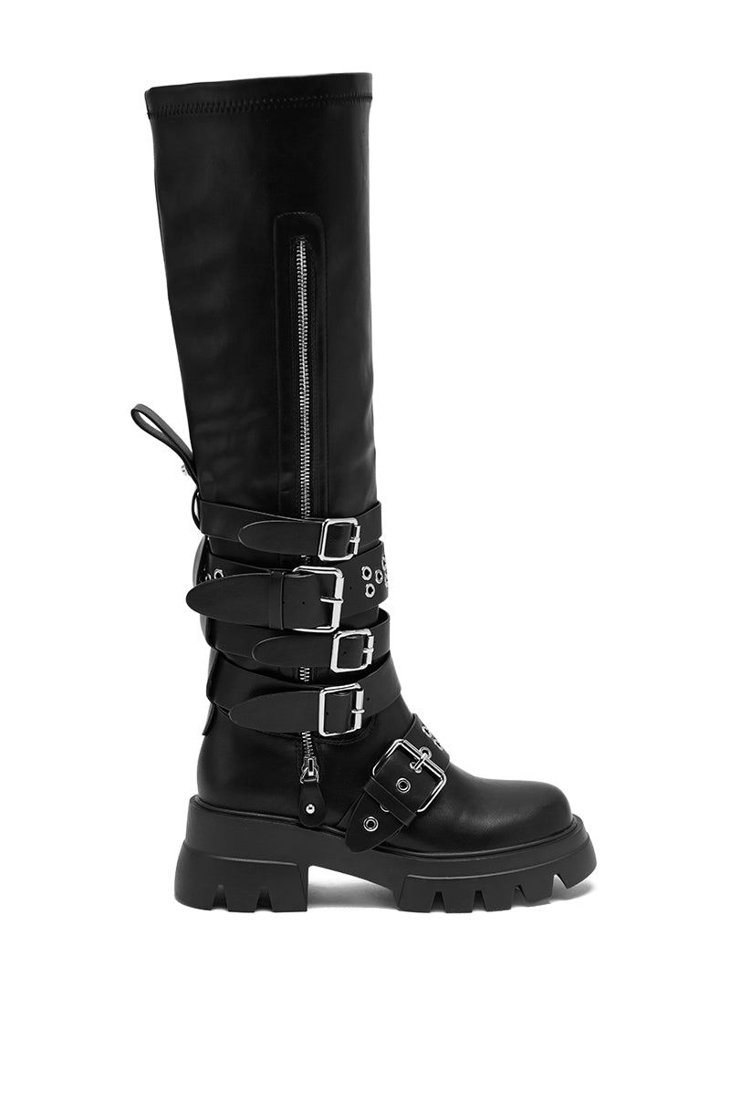The AZALEA WANG CORDOVAN BLACK BELTED BOOT is a knee-high boot in sleek faux leather, accented with stylish buckles.