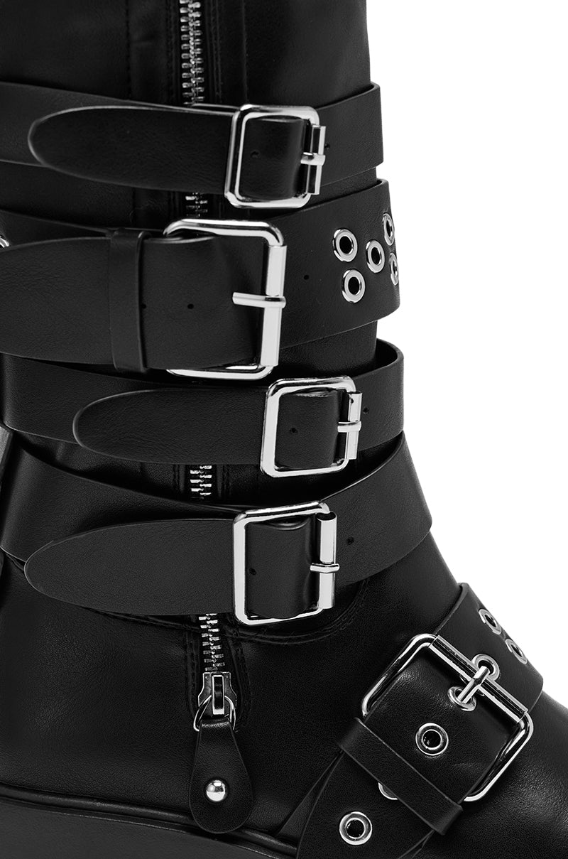A close-up of the AZALEA WANG CORDOVAN BLACK BELTED BOOT, a knee-high style crafted from sleek faux leather.