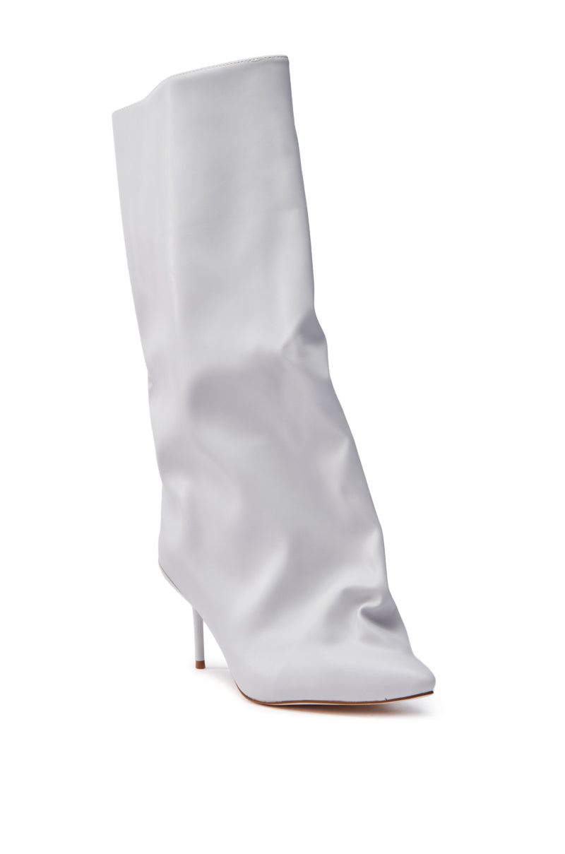 The AZALEA WANG COUTURE CRAZY BONE BOOT is a knee-high, white slouchy boot made from faux leather, featuring a pointed toe and thin stiletto heel with a soft, wrinkled texture that exudes modern style.