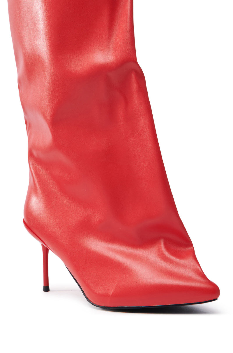 The AZALEA WANG COUTURE CRAZY RED BOOT is a knee-high stiletto with a pointed toe and thin heel, crafted from sleek vegan leather with a glossy finish.