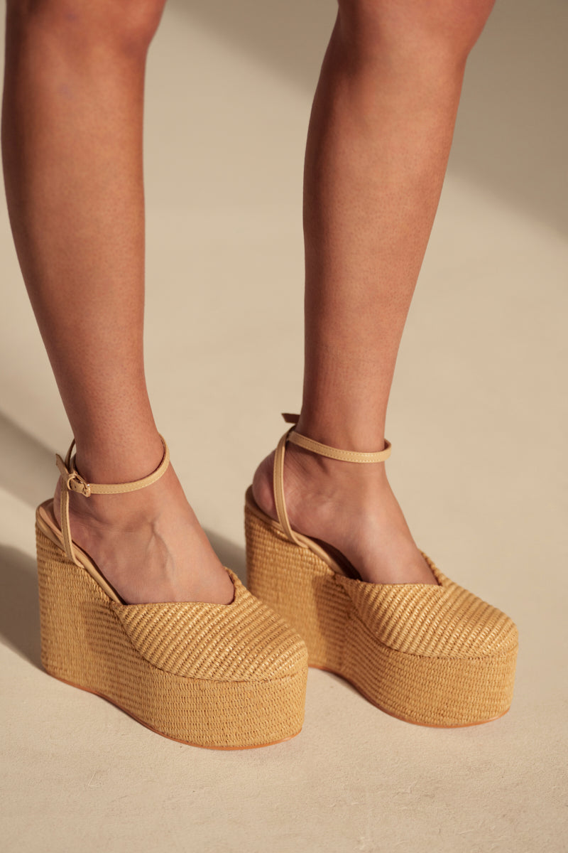A pair of legs modeling the AZALEA WANG COVA BEIGE WEDGE sandals with platform soles and adjustable ankle straps, featured against a neutral background.