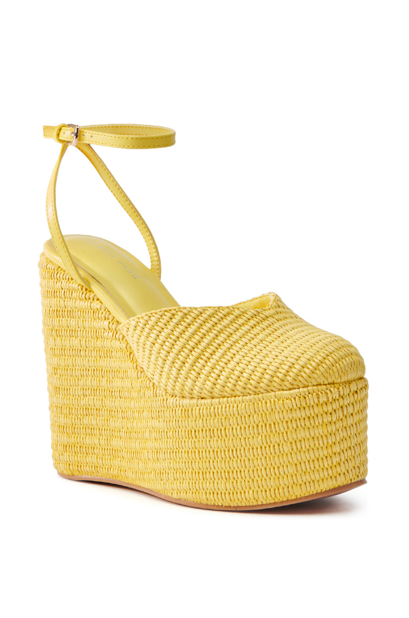 The AZALEA WANG COVA YELLOW WEDGE features a closed toe, platform sole, ankle strap, and wicker-like texture. It radiates a casual, summery vibe.
