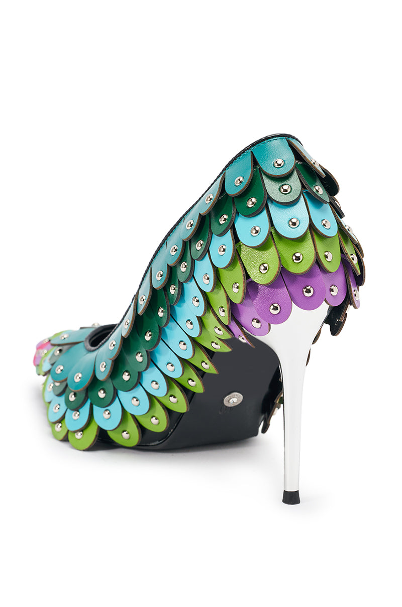 The AZALEA WANG CRISTATUS GREEN MULTI COLOR TEXTURED STILETTO PUMP features a faux leather upper with blue, green, and purple scale-like textures, silver stud accents, and a white high stiletto heel for a bold, dragon-inspired look.