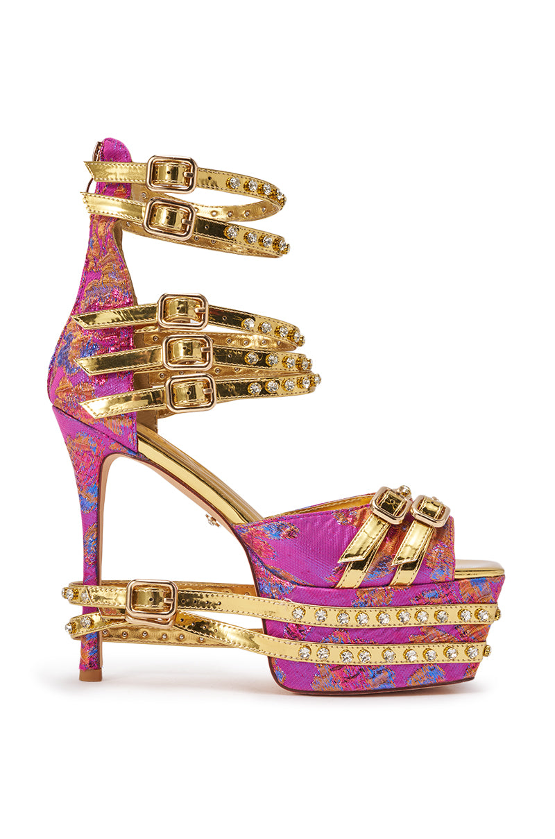 The AKIRA CRUSHIN PINK MULTI BROCADE AND GOLD EMBELLISHED STILETTO SANDAL boasts pink brocade, blue floral patterns, jewel-studded straps and buckles, plus a rhinestone platform—perfect statement heels for brunch. 2