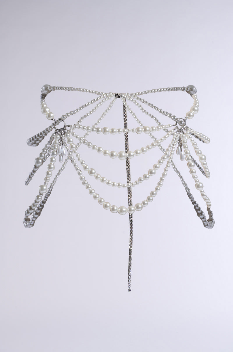 The COCO PEARL CHAIN BELT features a butterfly-inspired design with silver chains and pearl strings. Crystal-like pendants hang from its wings, enhancing the elegant accessory's intricate design as pearlescent beads shimmer against a plain background.