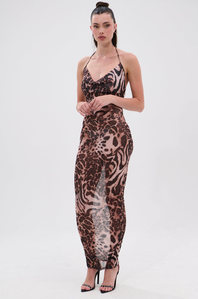 A woman poses against a white background in the ON TREND Mesh Midi Dress in Animal Print—a sleeveless, form-fitting design with a slit, styled with black high-heeled sandals for a bold, fashion-forward look. 2