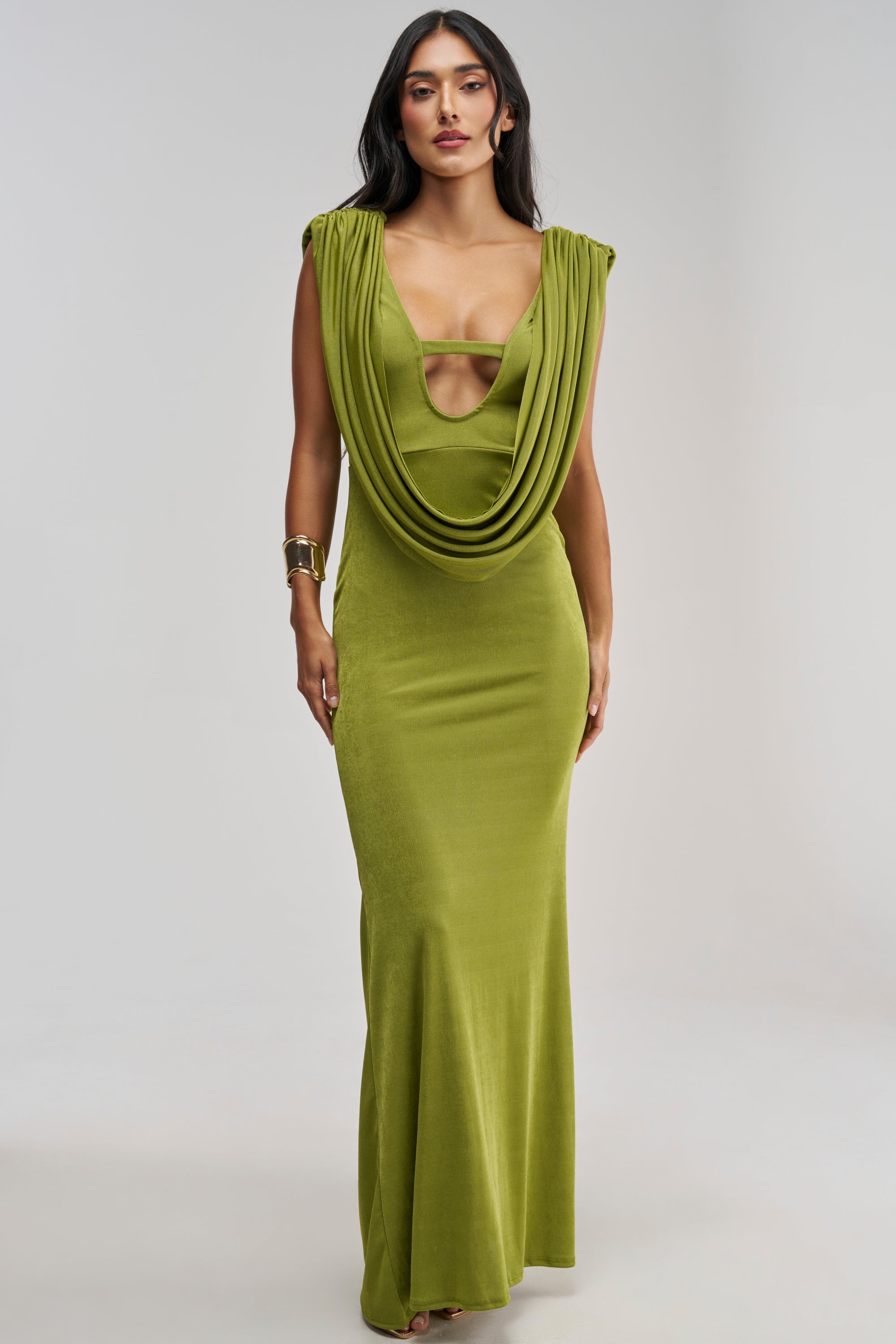 Woman wearing the HOTTER THAN EXPECTED MAXI DRESS—a sleeveless, floor-length chartreuse maxi dress featuring a draped neckline and chest cutout detail—posing against a neutral background for an effortlessly chic look that’s perfect as an evening gown or wedding guest dress.