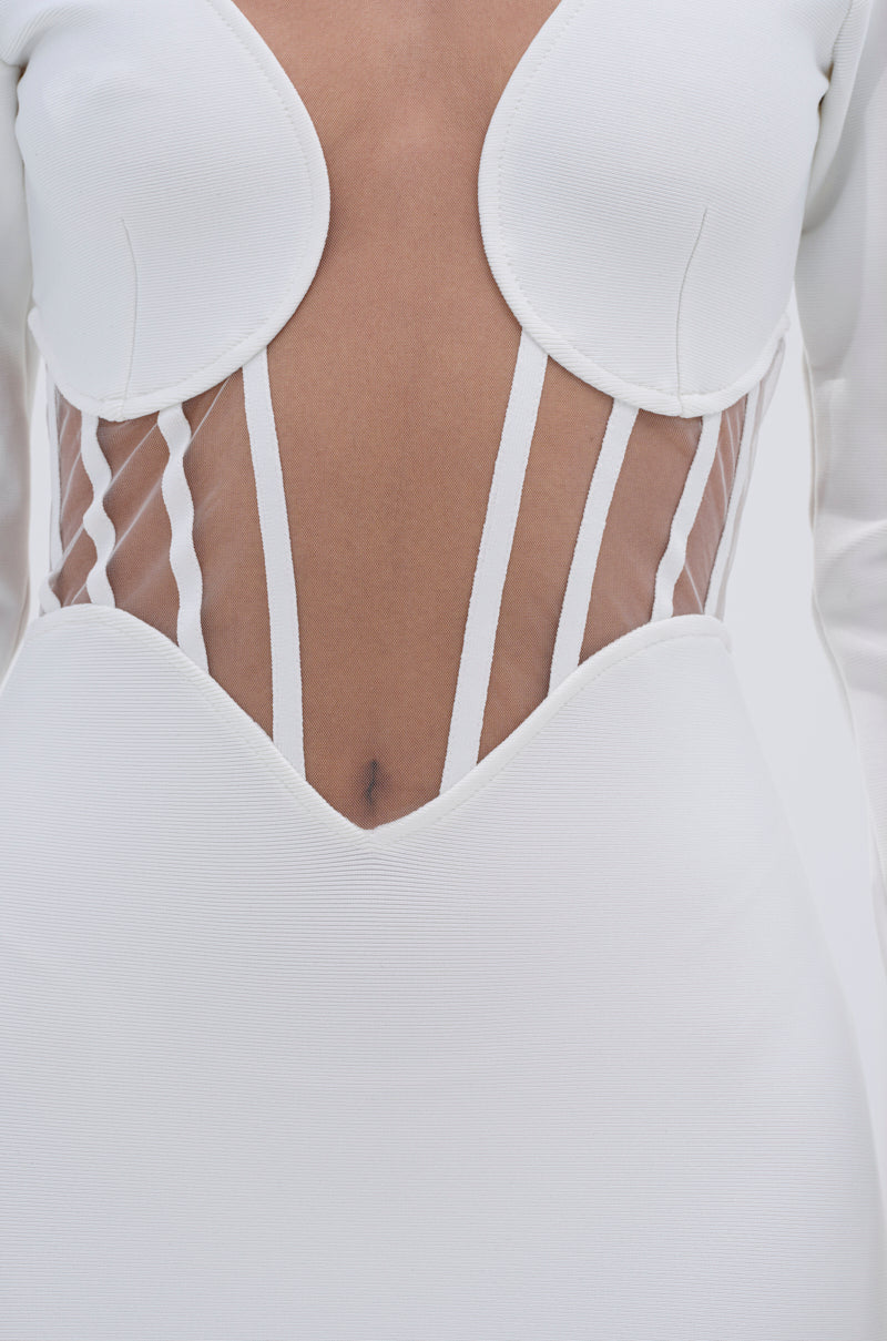 Close-up of a person wearing the A NIGHT OUT BANDAGE MAXI DRESS IN WHITE, featuring sheer mesh panels with vertical strips at the midsection, structured cups, sculpted bust detail, and a plunging neckline.